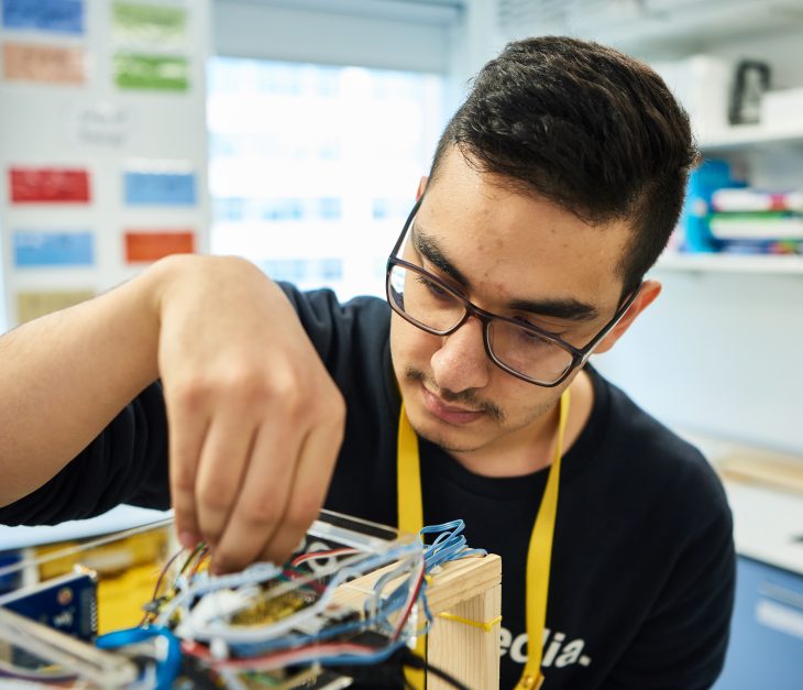 student adding wires into box