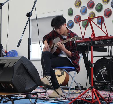 Student playing the acoustic guitar