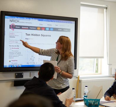Mathematics teacher using digital teaching screen at Abbey College Cambridge