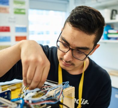 student adding wires into box