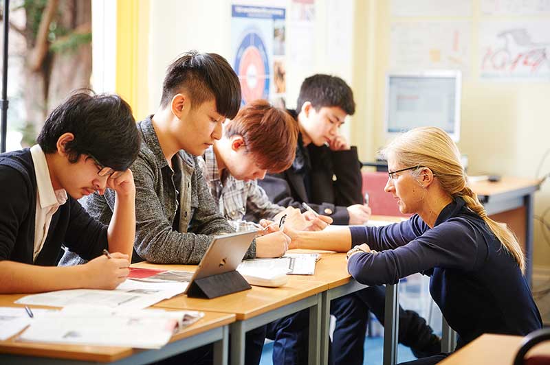 students working with the teacher helping