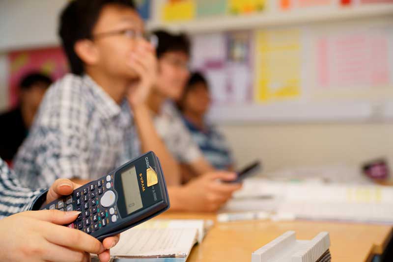 A student holding a calculator