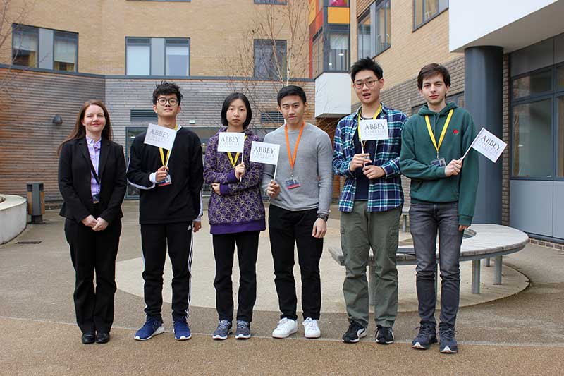 students holding college flags