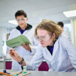 Male Students Taking Part In A Chemistry Practical Session
