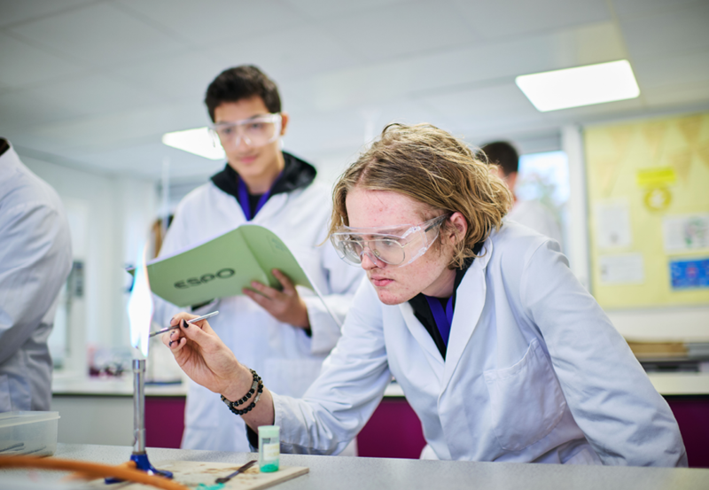 Male Students Taking Part In A Chemistry Practical Session