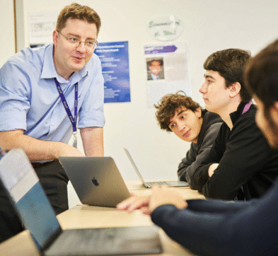 Teacher Talking To Students In Economics Class At Abbey College Cambridge