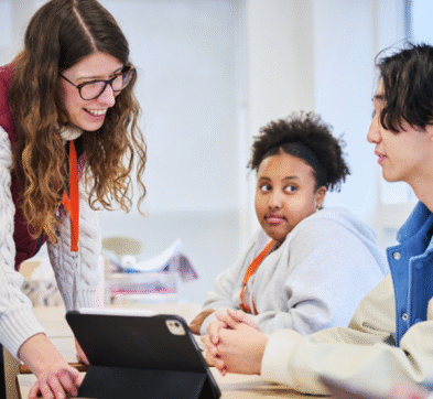 Teacher Working With Students In Class At Abbey College Cambridge